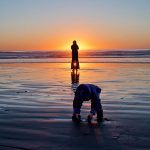 Child with Mother at Beach During Sunset
